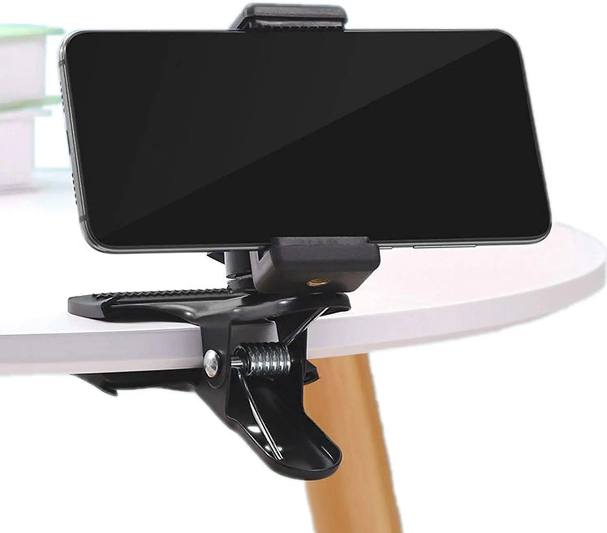 A black phone mount with a rotating mechanism is shown attached to a table surface.