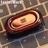 A close-up of a metallic fidget slider with a red and gold gem design resting on a keyboard.