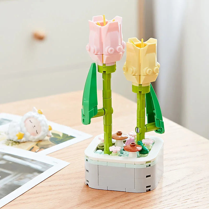 A set of pink and yellow rose flower building blocks arranged in a bouquet on a wooden table.
