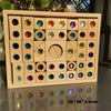 A wooden box filled with colorful gemstone building blocks and acrylic crystals.