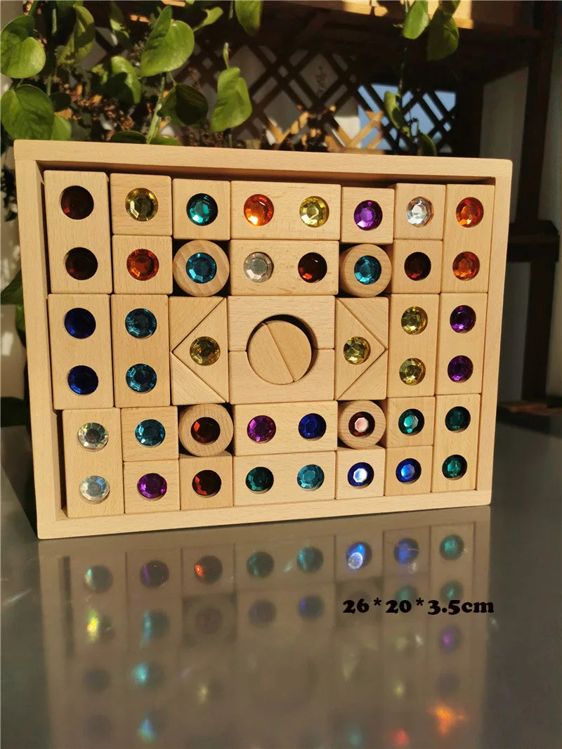 A wooden box filled with colorful gemstone building blocks and acrylic crystals.