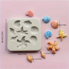 A set of pink and blue silicone baking molds shaped like seashells, starfish, and spirals.