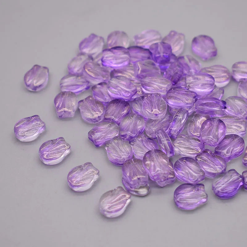 A pile of small, translucent purple tulip flower glass beads.