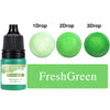 A bottle of FreshGreen liquid candle dye with three dropper bottles showing 1, 2, and 3 drops of the green liquid.