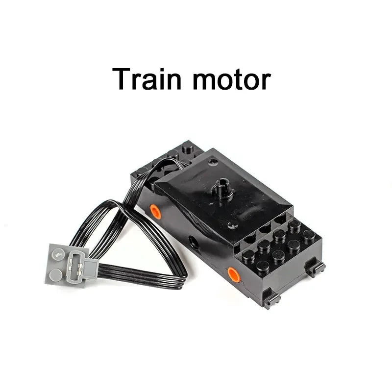 A black train motor with wires and connectors is shown.