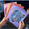 A hand holds a stack of colorful 3D cartoon scene stickers for scrapbooking and journaling.