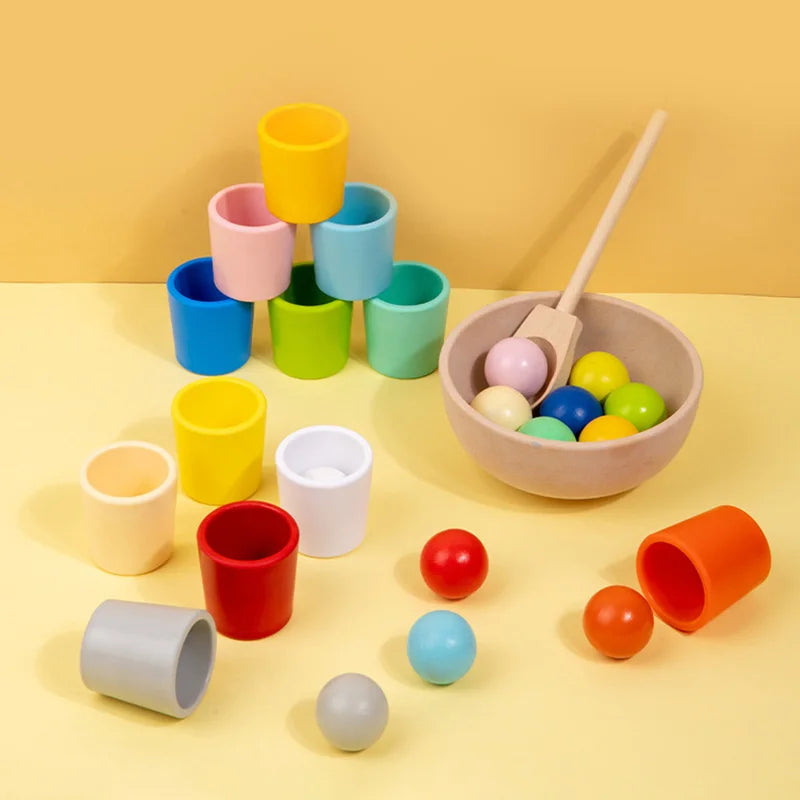 Eine Sammlung bunter Holzsortierbälle und ein Holzschöpflöffel auf einem hellgelben Hintergrund.