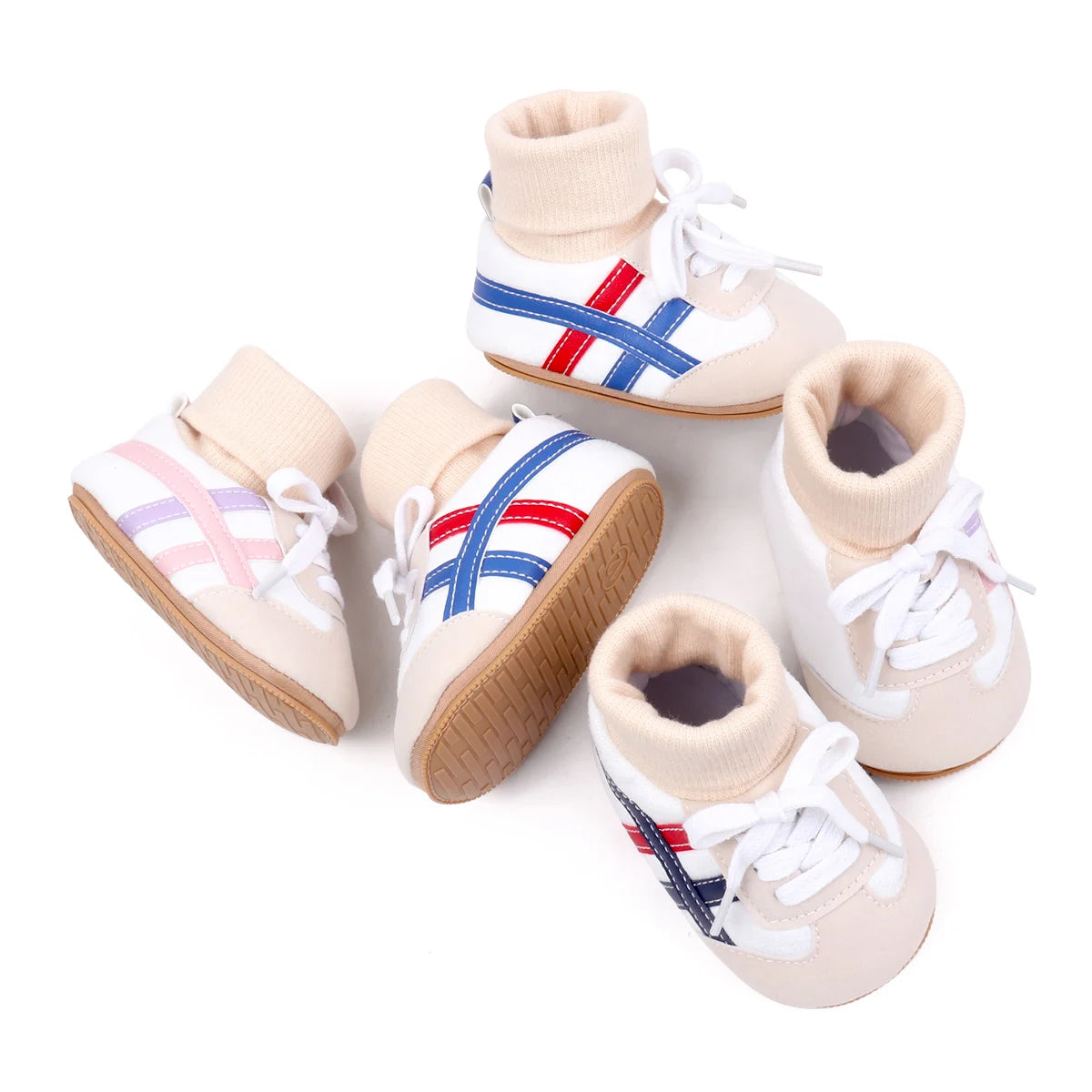 A pair of white baby booties with blue and red stripes and tan soles.