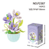 A bouquet of purple and white flowers with green leaves displayed in a light blue pot.