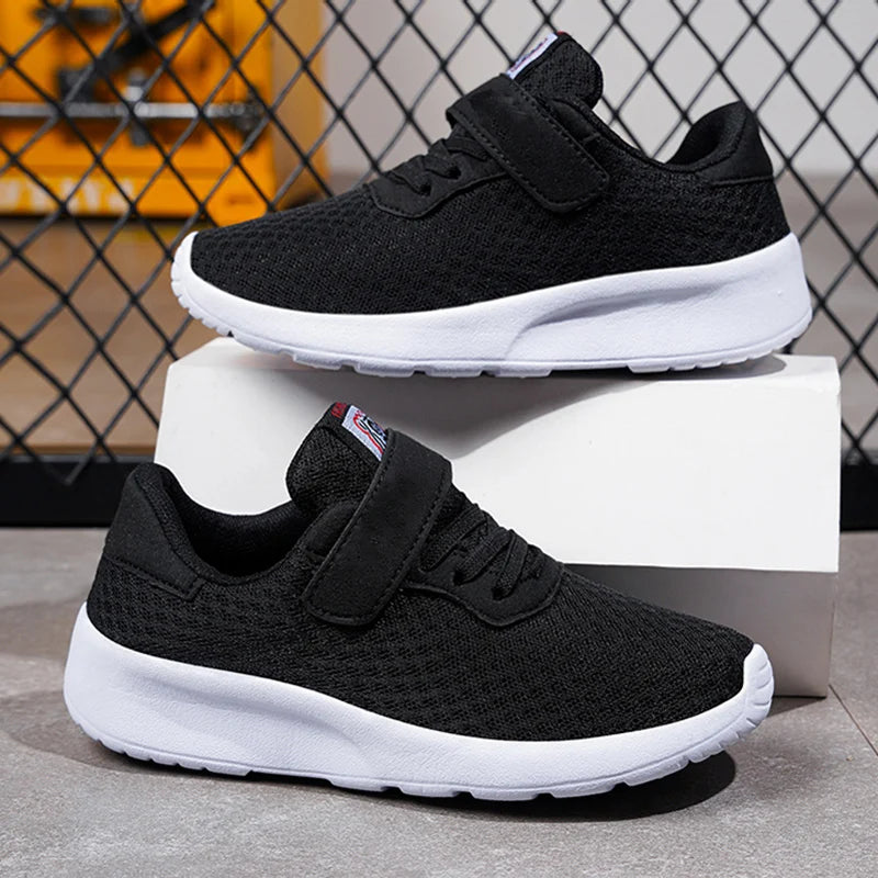Black breathable mesh kids sneakers with white soles displayed on a white box.