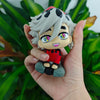 A hand holds an action figure of the Demon Slayer character Tanjirou, featuring white hair and a red outfit.