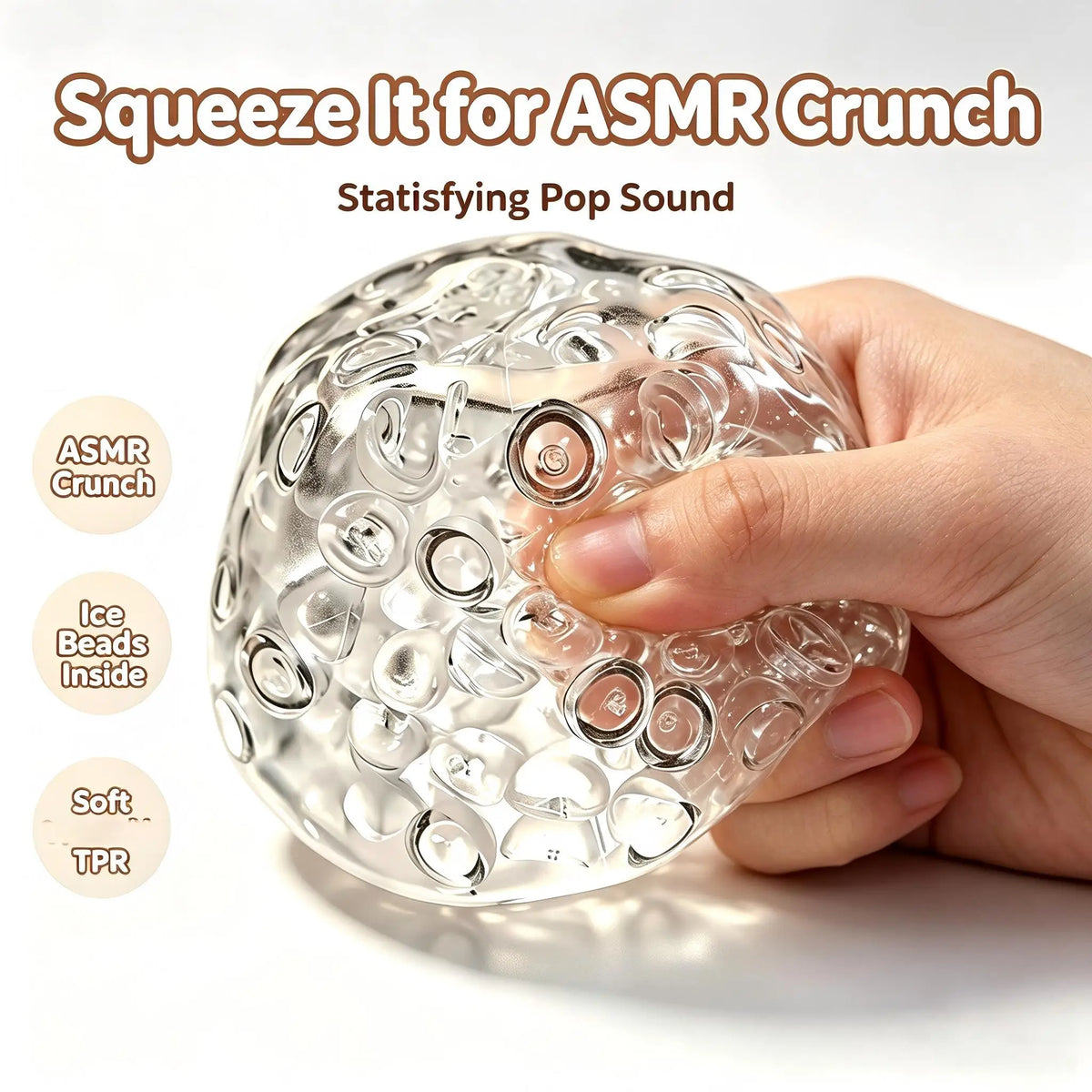 A hand squeezes a clear, spherical stress relief ball filled with ice beads for an ASMR crunch sound.