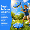 A happy boy throws a blue squeeze-and-throw flying saucer ball outdoors, demonstrating hand-eye coordination.