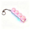 A clear acrylic keyboard keychain fidget toy featuring pink paw prints and an LED light.