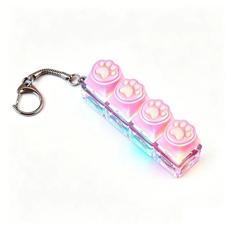 A clear acrylic keyboard keychain fidget toy featuring pink paw prints and an LED light.