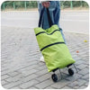 A lime green foldable portable shopping cart with black straps is shown on a paved sidewalk.