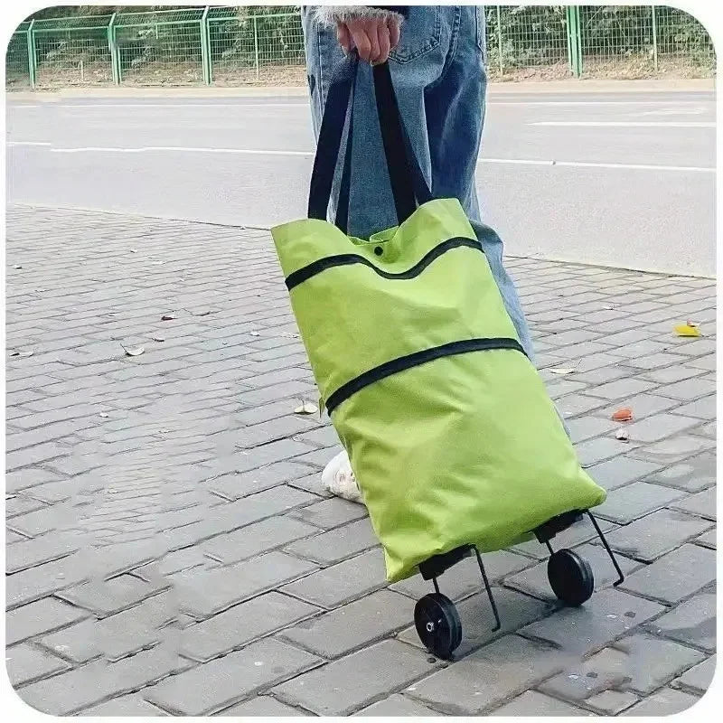 A lime green foldable portable shopping cart with black straps is shown on a paved sidewalk.