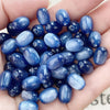 A handful of iridescent blue and purple resin star-like cat's eye beads for jewelry making