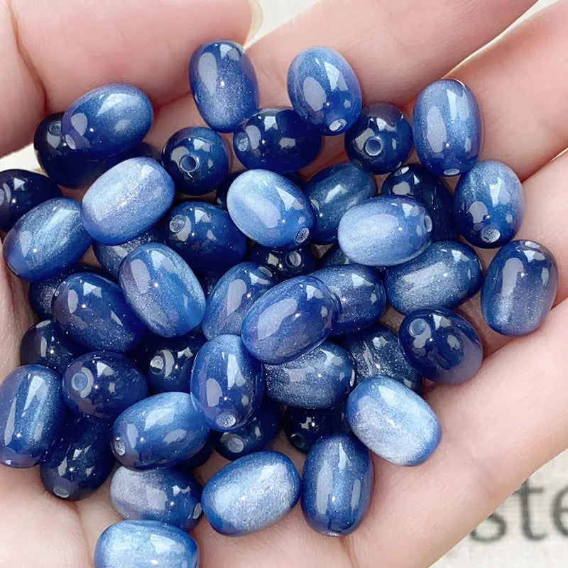 A handful of iridescent blue and purple resin star-like cat's eye beads for jewelry making
