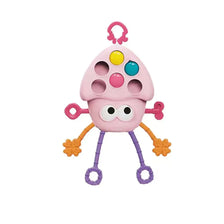 A pink baby pull-string sensory toy with silicone teether featuring multiple colored holes and dangling limbs.