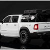 A white RAM TRX diecast pickup truck model displayed against a dark background.