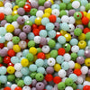 Mixed color faceted rondelle glass beads in various shades of green, yellow, pink, and white for jewelry making
