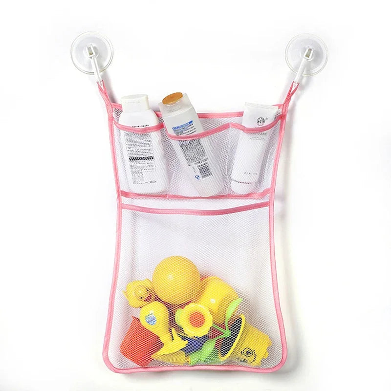 A pink mesh storage bag with suction cups holds various toiletries and yellow duck and frog toys.