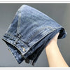 A close-up shot of a pair of vintage loose fit denim harem jeans folded and held by a hand.