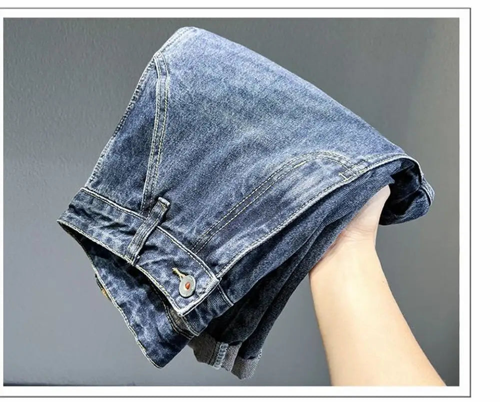 A close-up shot of a pair of vintage loose fit denim harem jeans folded and held by a hand.