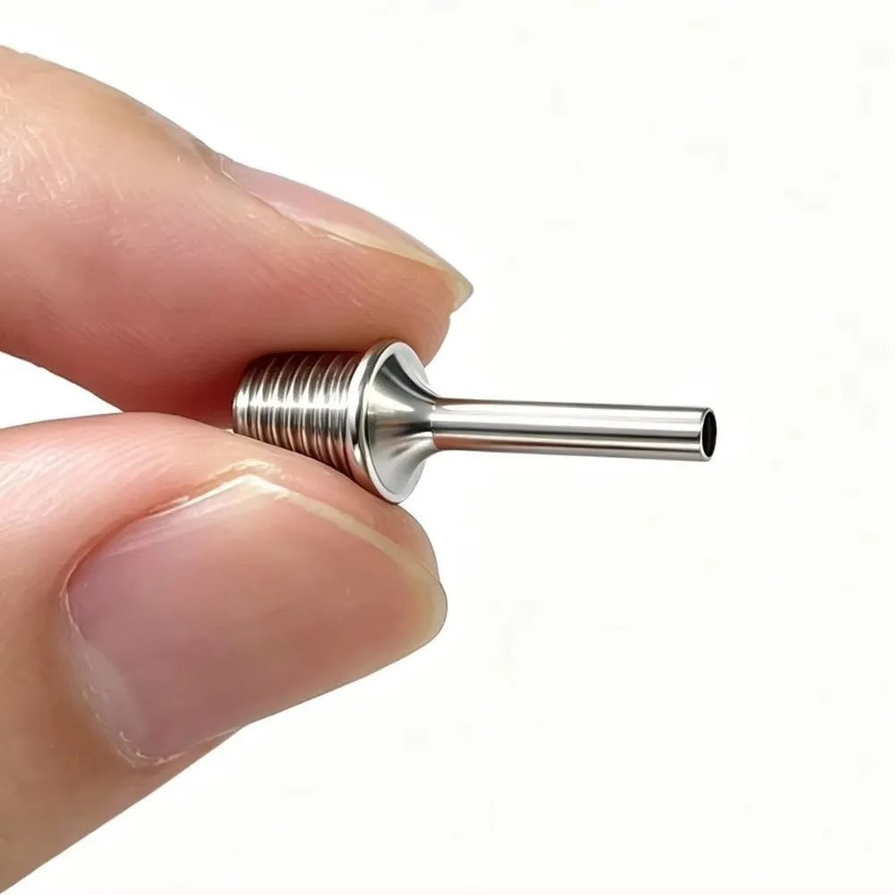 A hand holds a silver metal ultra-fine diamond painting pen tip replacement, showing its cylindrical shape.