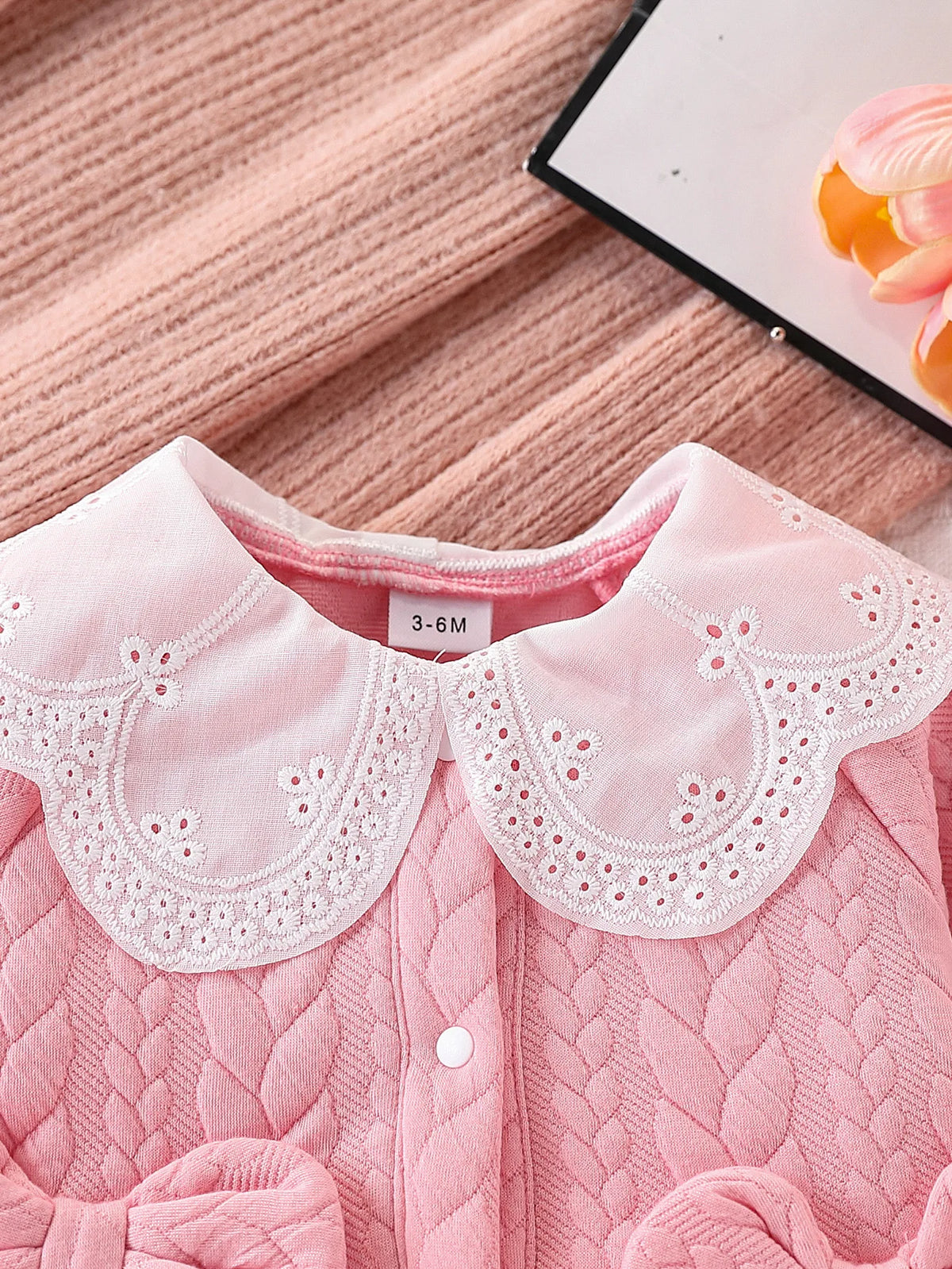 Pink quilted baby girl romper with a white lace collar and pink fabric