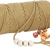 A large spool of natural beige cotton macrame rope with a loose end and several small decorative beads.