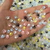A hand displays a collection of luminous cat paw nail art charms in various pastel colors for DIY crafts.
