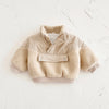 A beige toddler fleece-lined winter coat with a half-zip collar and textured sherpa sleeves.