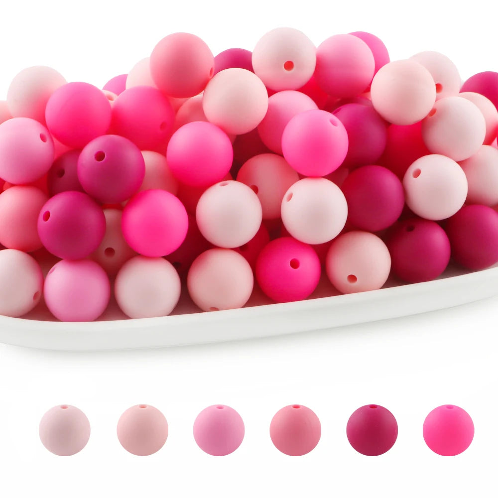 A pile of round silicone beads in various shades of pink and magenta for jewelry making