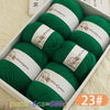 A box containing six balls of green wool yarn for knitting