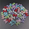 A scattered collection of 20 colorful acrylic bow beads in various shades of pink, purple, blue, and green.