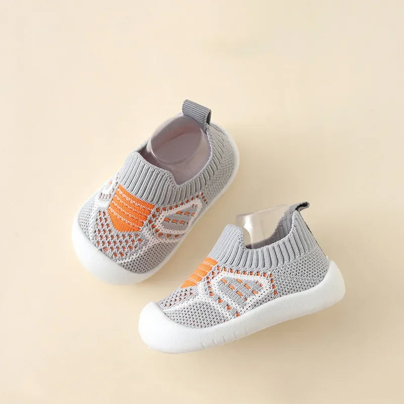 A pair of gray and orange breathable anti-slip baby first walker shoes shown from above.