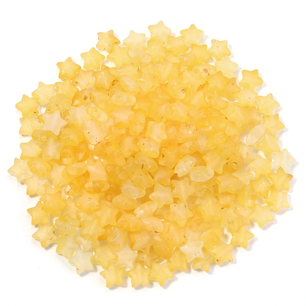 A pile of small, yellow transparent star-shaped acrylic beads for jewelry making.