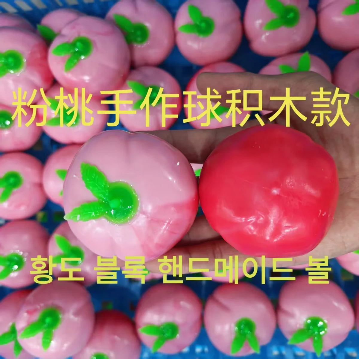 Pink and red squishy toys shaped like apples are shown in a blue tray.