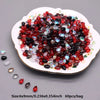 A pile of red and black water drop Czech glass beads for jewelry making displayed on a white plate.