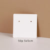 A white square jewelry display card with two small circular cutouts is shown against a beige background.