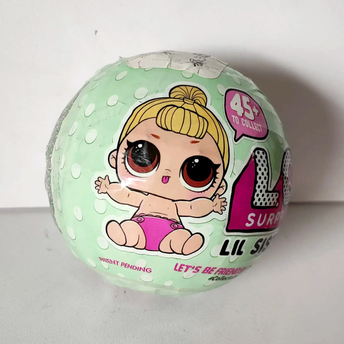 A green blind ball from the LOL Surprise! Lil Sisters Series 2 collection featuring a character illustration.
