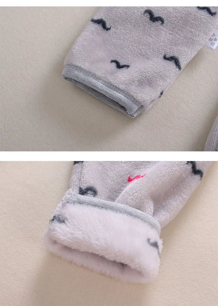 A close-up of a gray fleece jacket and pants set with black cartoon animal prints on a light background.