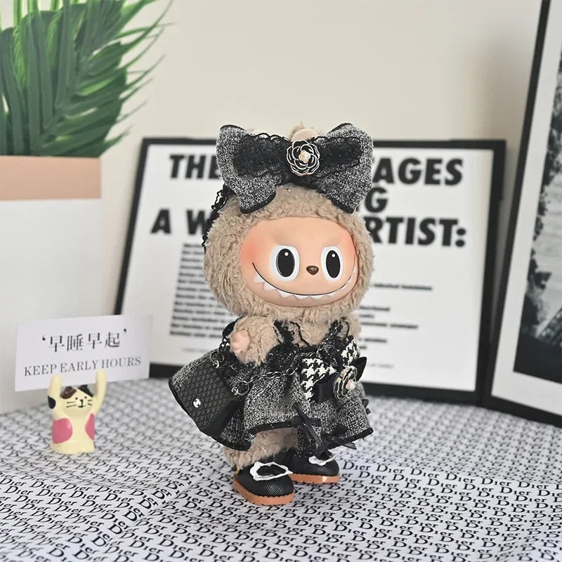 A plush Labubu doll wearing a black flannel outfit with a bow, displayed in front of a framed sign.