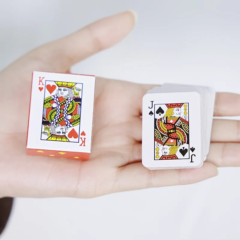 A hand holds a set of portable mini playing cards, including King and Jack cards.