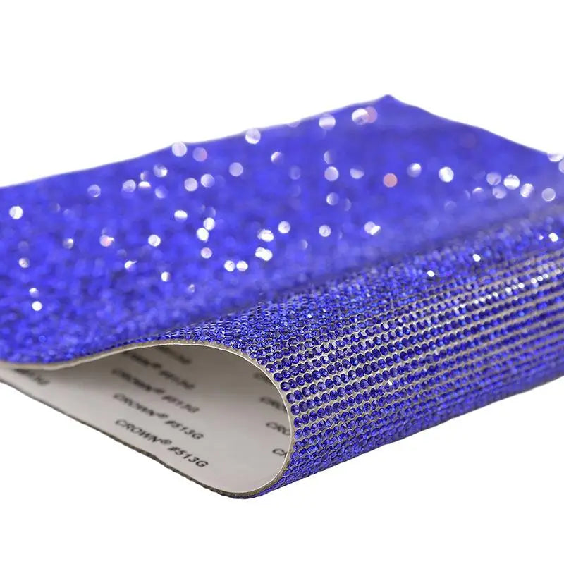 Blue sparkling rhinestone adhesive tape rolled up, showing glittery texture and clear adhesive side.