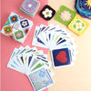 Collection de carrés granny crochet colorés et cartes de patrons de tricot sur fond rose.