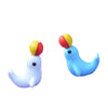 Two miniature animal figurines, one white and one blue, with yellow and red accents.