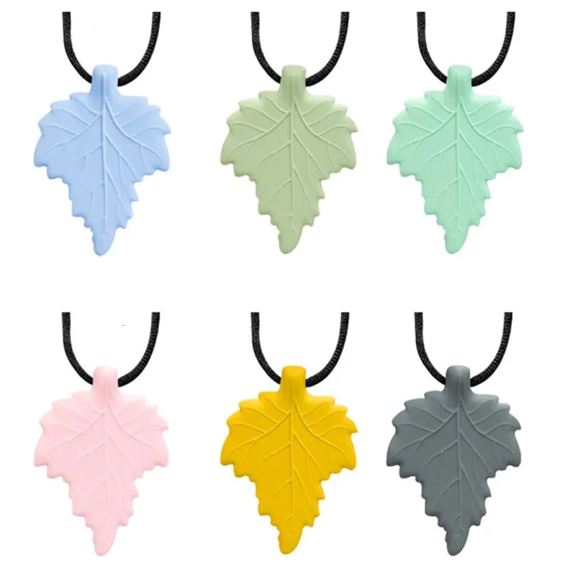 A set of silicone chew necklaces shaped like leaves in various pastel and earthy tones.